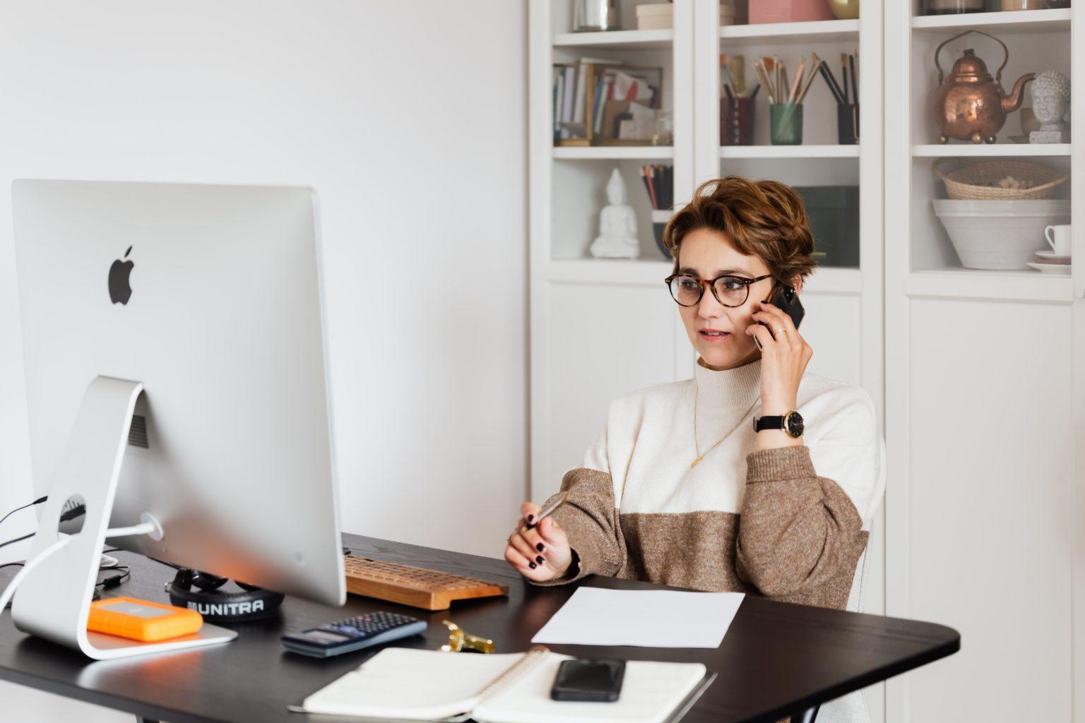 Profissional ao telefone a trabalhar no computador