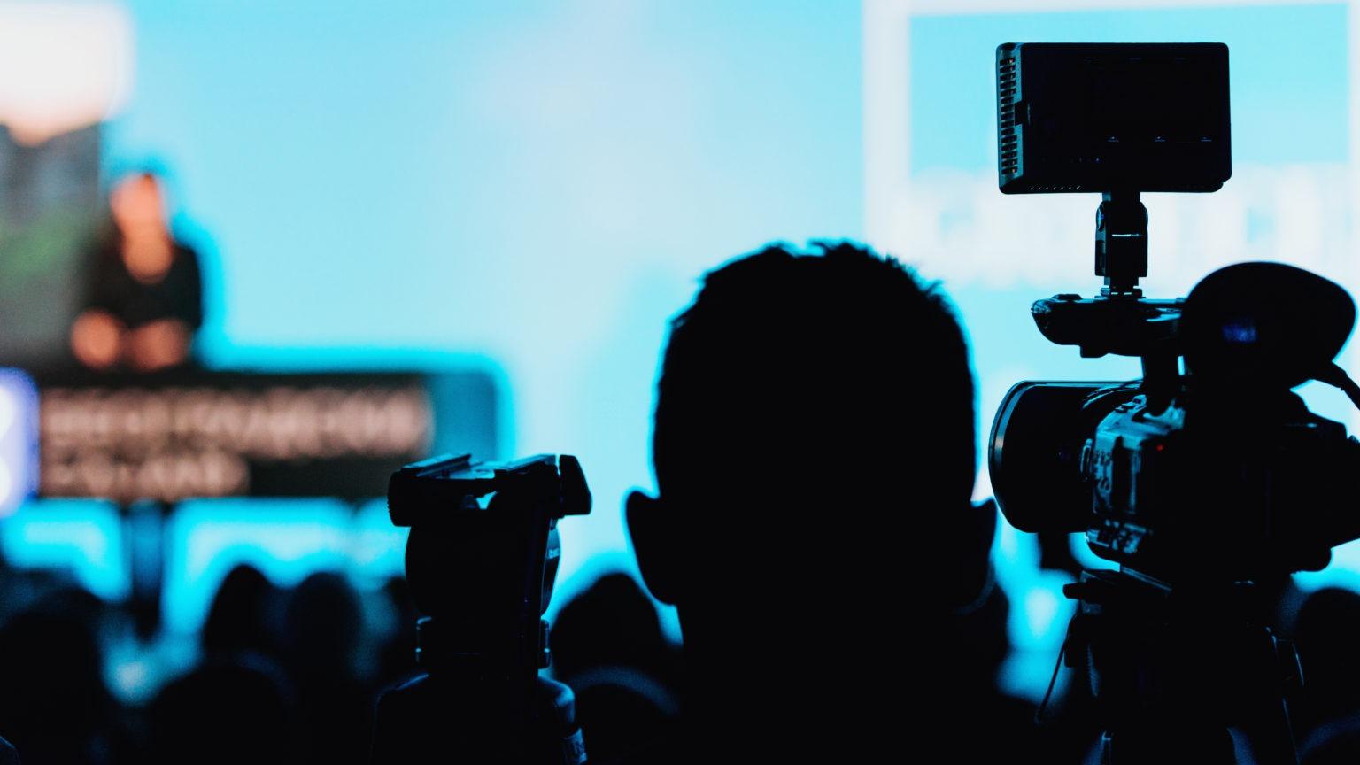 Camera recording a presentation in front of an audience