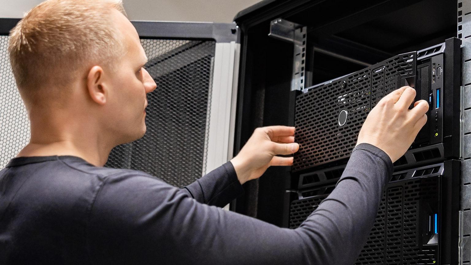 Technician installing servers in a data center rack