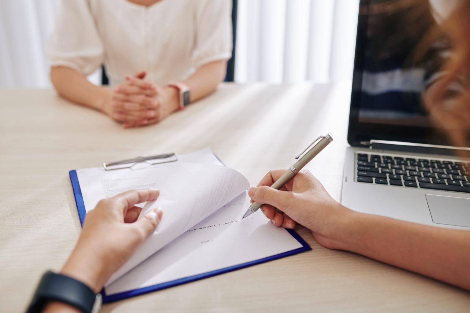 Duas pessoas a assinar um contrato sobre a mesa